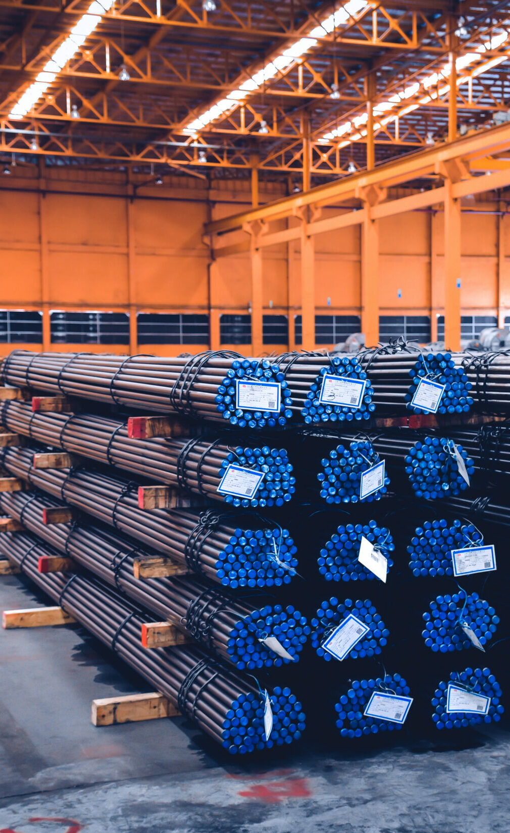 Pack of steel round bar stack in layer inside large distribution warehouse. Steel warehouse logistics operations.
